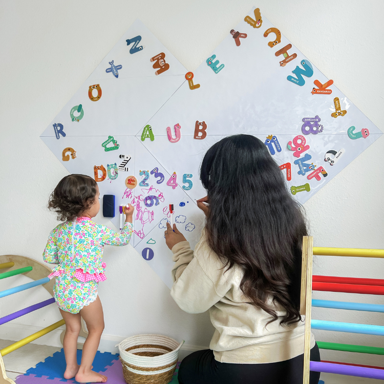 Little girl and mom drawing with magnetic board