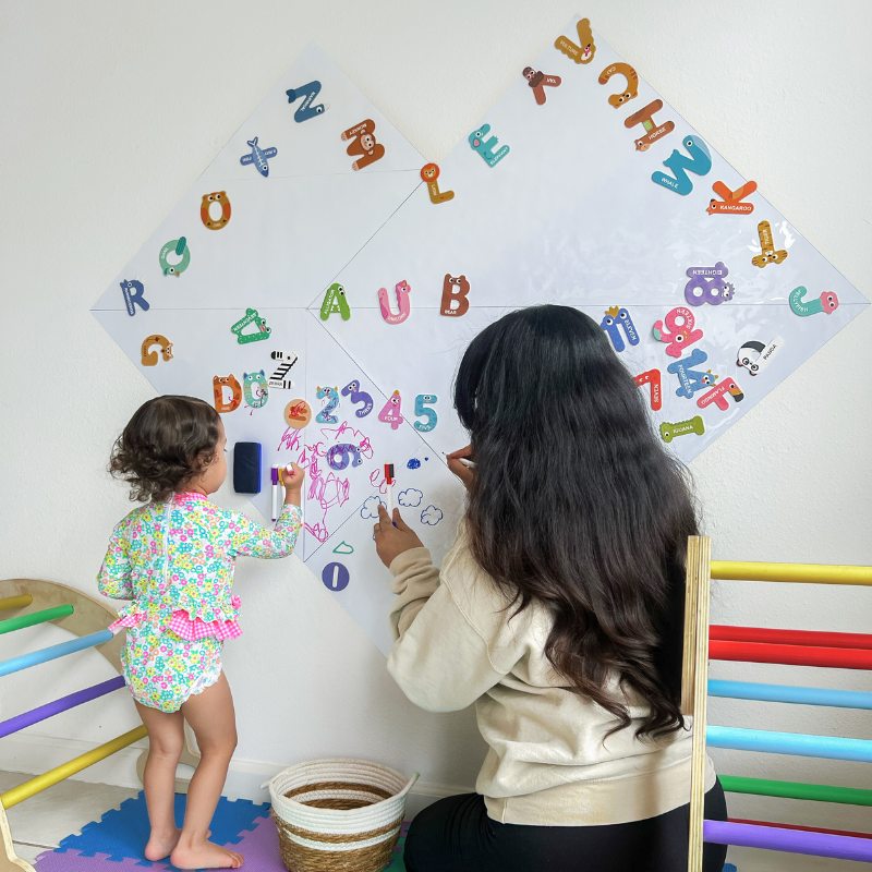 Little girl and mom drawing with magnetic board