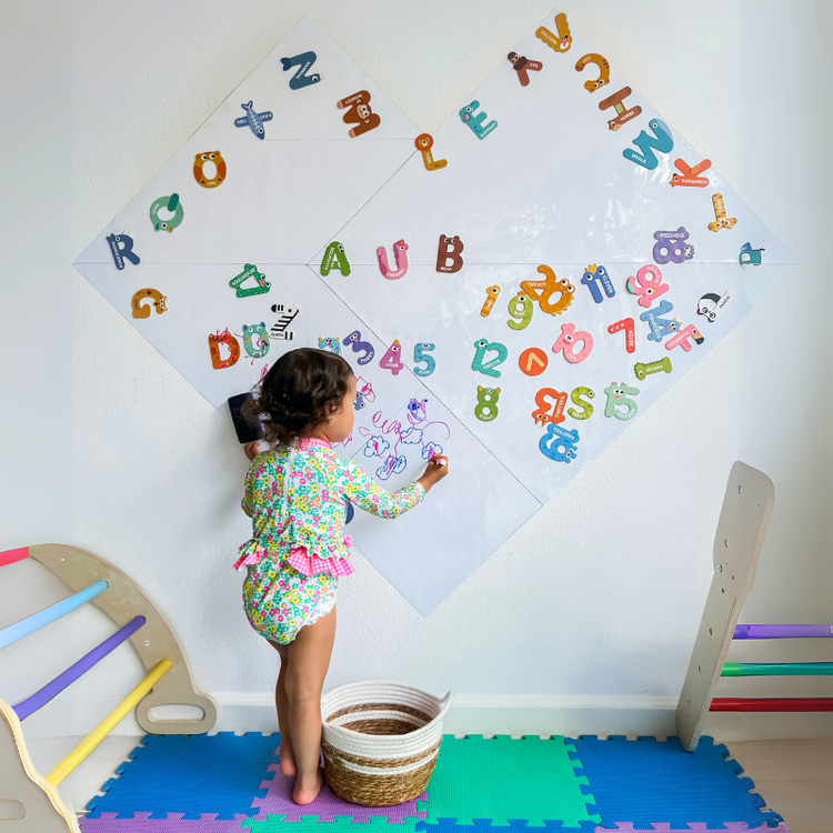 Girl is using magnetic board in playroom