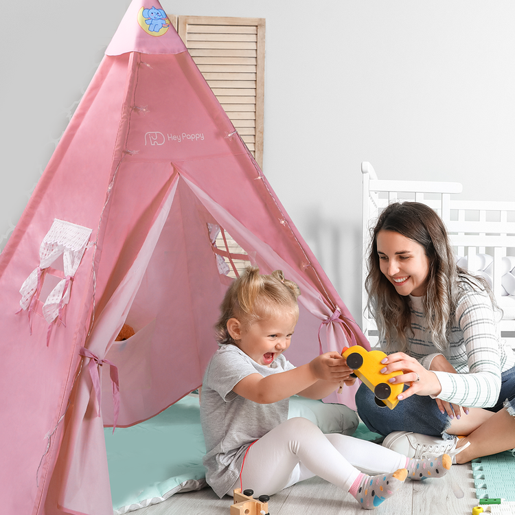 mom and baby playing near the pink tent