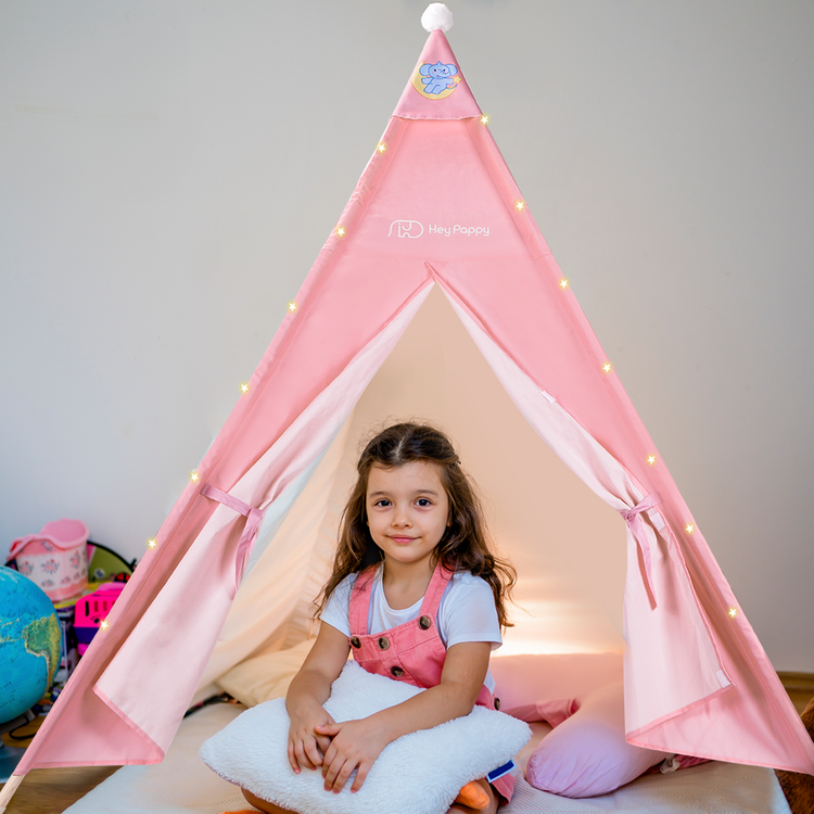 Little girl sitting inside the pink tent