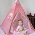 baby girl sitting indise the pink tent