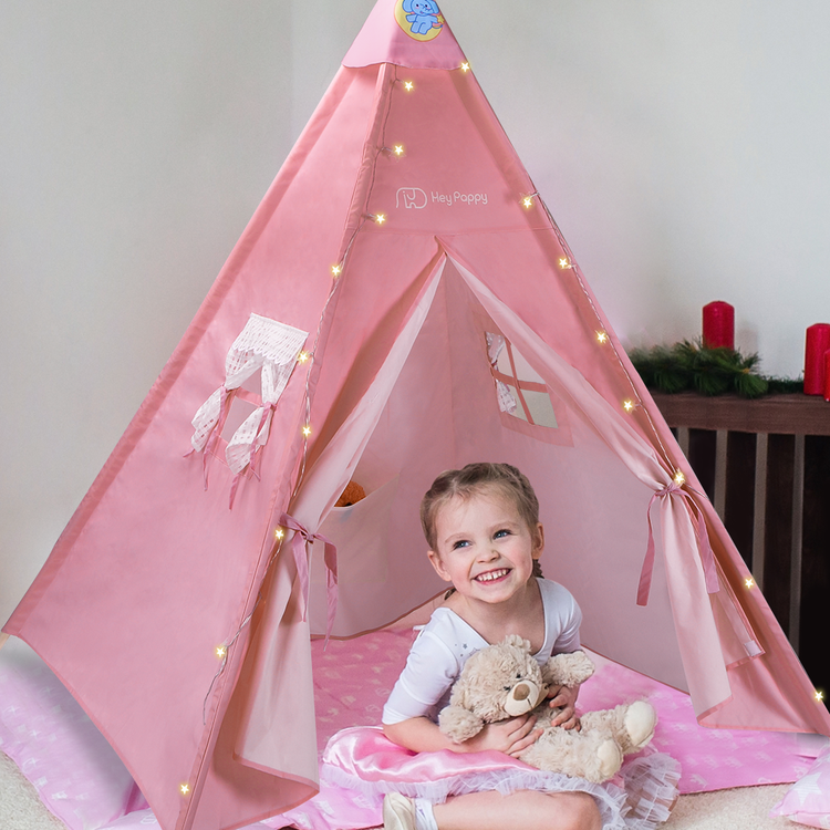 baby girl sitting indise the pink tent