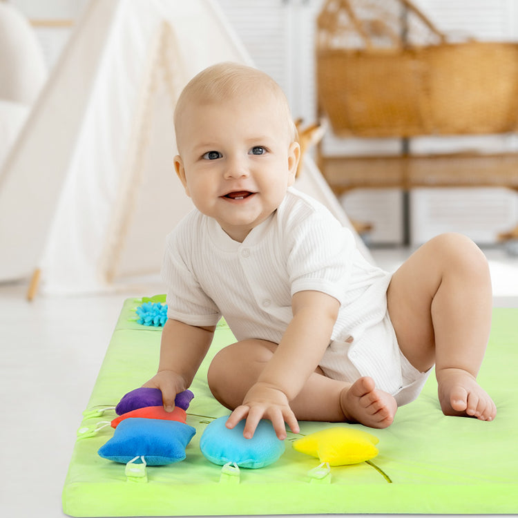 Baby sitting on green sensory mat
