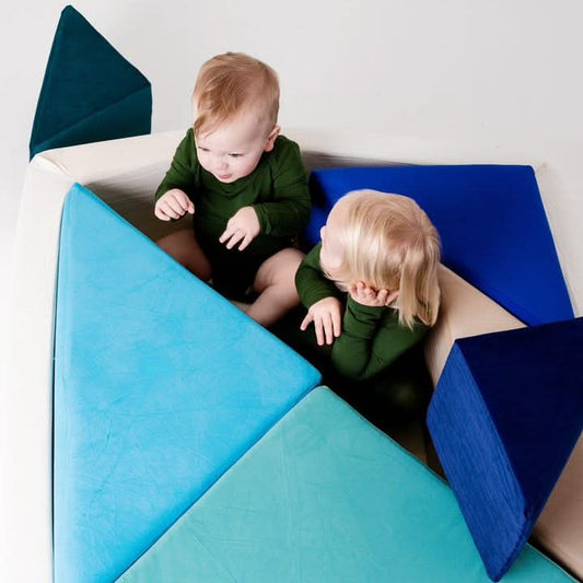Two kids are sitting inside the tangram couch.