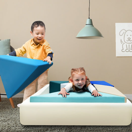 A kid holding a module of the sofa, and another child lying on the tangram couch.