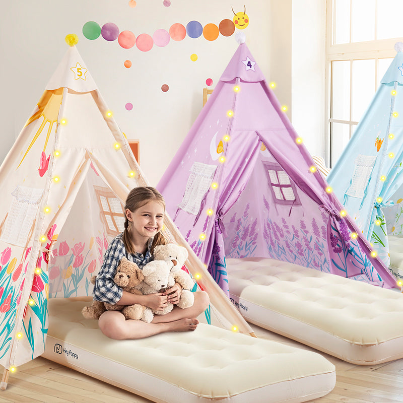 A little girl is sitting on an inflatable air mattress with a plush toy in a beige tent.