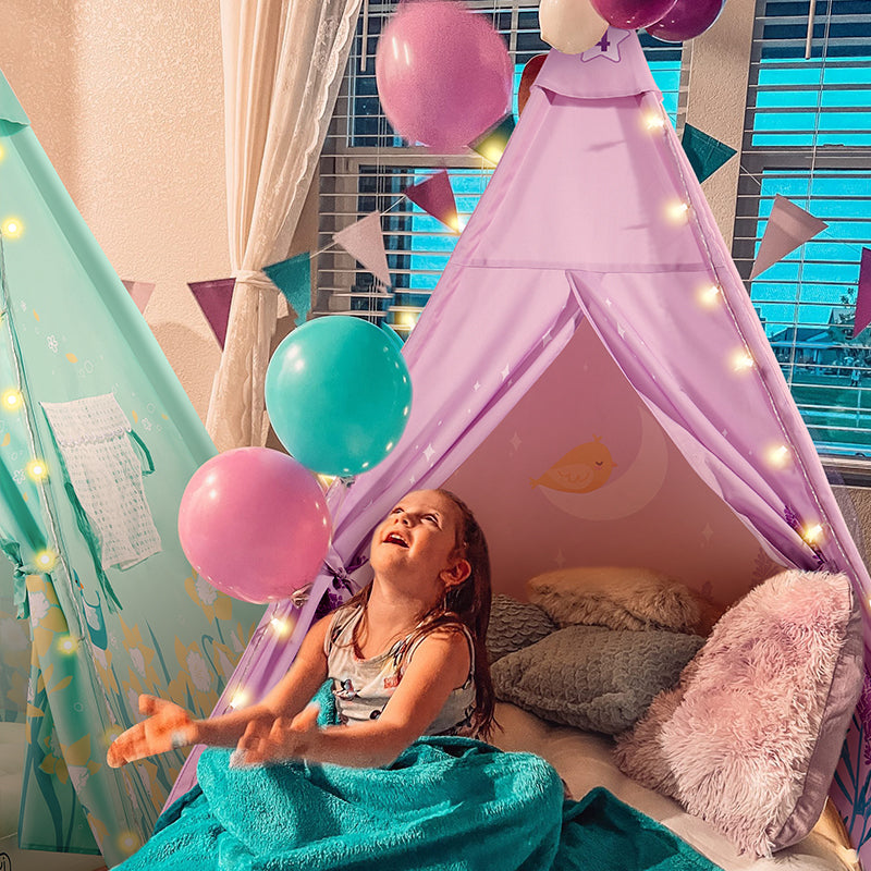 A little girl is sitting inside a purple kid's tent full of balloons.